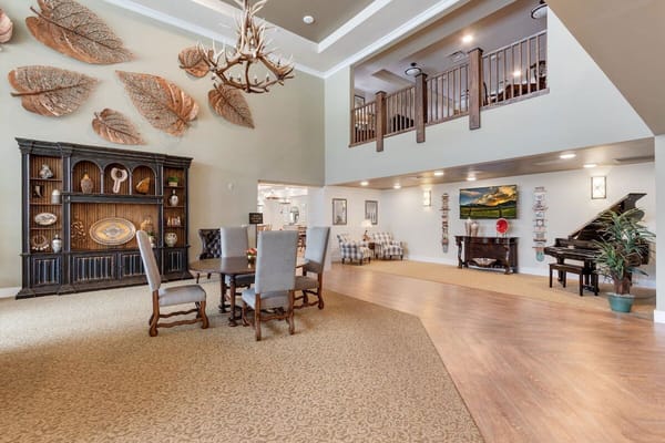 A view of the living room featuring seating, a piano, and decorative wall art.