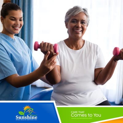 Senior woman engaging in an exercise session with a caregiver, using light weights