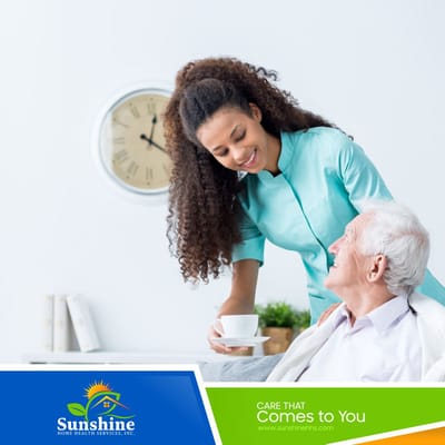 A caregiver serving a cup of tea to a smiling senior resident.