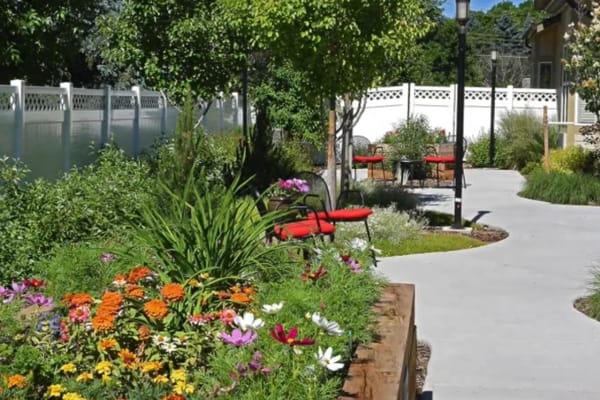 Lush garden paths with colorful flowers and seating areas.