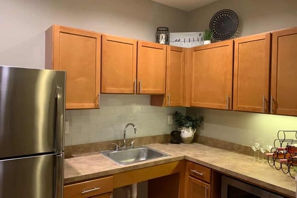 A modern kitchen with stainless steel appliances and wood cabinets