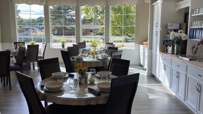 Bright dining room with large windows and flower centerpieces