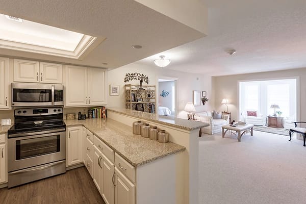 Modern kitchen with living room view in senior living facility