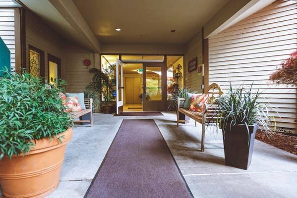 An inviting entrance with benches and potted plants.