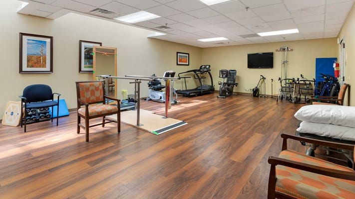 Spacious rehabilitation room with exercise equipment.