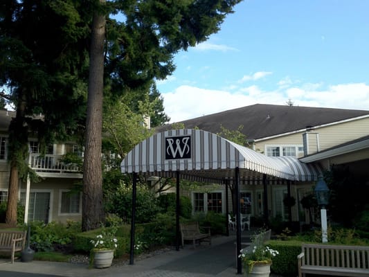 Entrance of Weatherly Inn Tacoma with a striped awning.