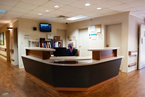 Receptionist at the front desk in a healthcare facility.