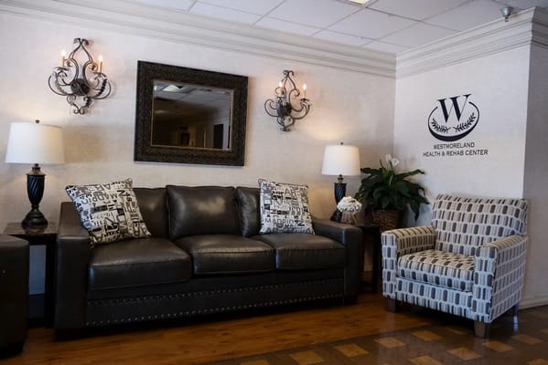 Cozy lobby seating area with a leather sofa and pattern chairs.
