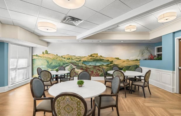 Bright and welcoming dining area with tables and a scenic mural.