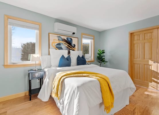 Brightly lit private resident room with bedding and decor