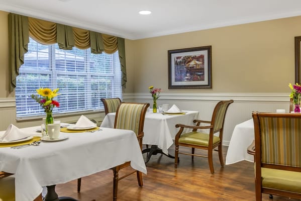 Dining room with tables set for meals and flowers