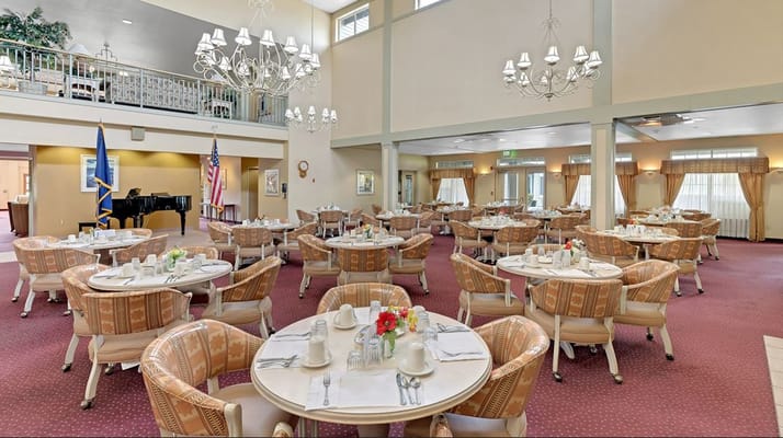 Spacious dining room with round tables and decorative chandeliers