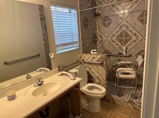 Accessible bathroom with grab bars and shower chair