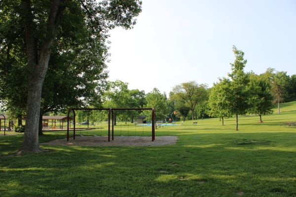 Playground with swings and green trees