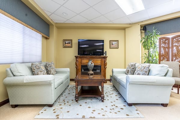 Comfortable seating in a lounge area with a TV and decorative elements.