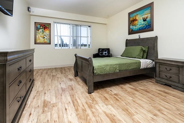 Cozy bedroom with a bed, dresser, and artwork