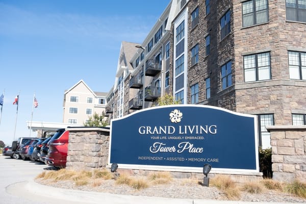Sign for Grand Living At Tower Place featuring multiple care options