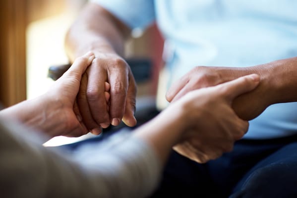 Two hands clasping in a caring gesture