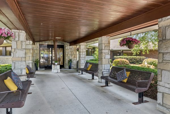 Covered outdoor seating area with benches and flowers
