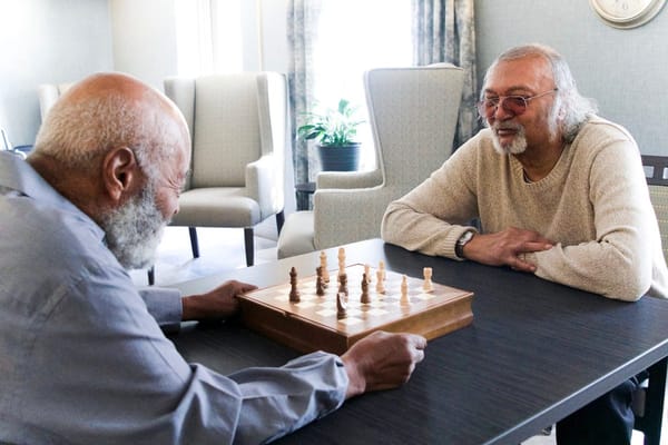 Two residents playing chess in a common area