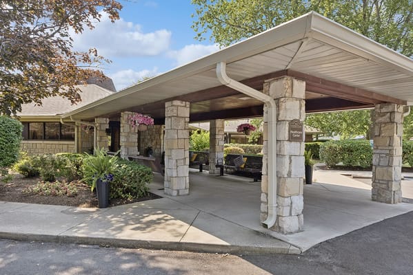 Covered entrance with flowers and seating area