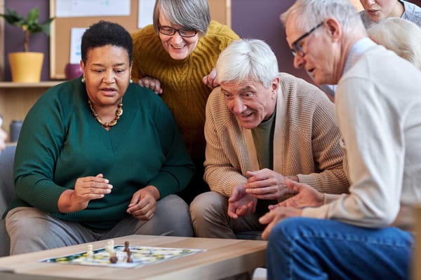 Residents enjoying a board game in a cozy activity room