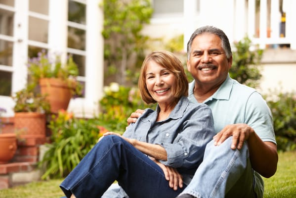Happy couple sitting on the lawn in a garden setting