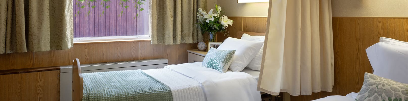 A well-furnished resident room with a bed and decor