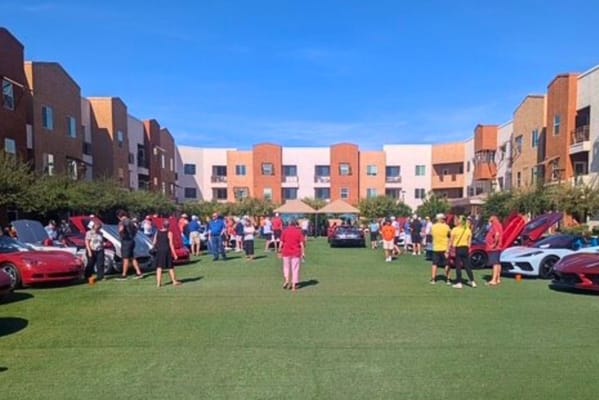 Residents and staff enjoying a car show in the courtyard
