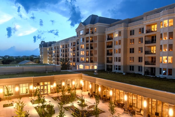 Exterior view of the facility at dusk with illuminated patios