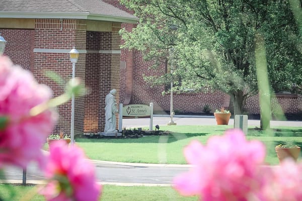 Exterior view of St. Anne's facility with garden flowers