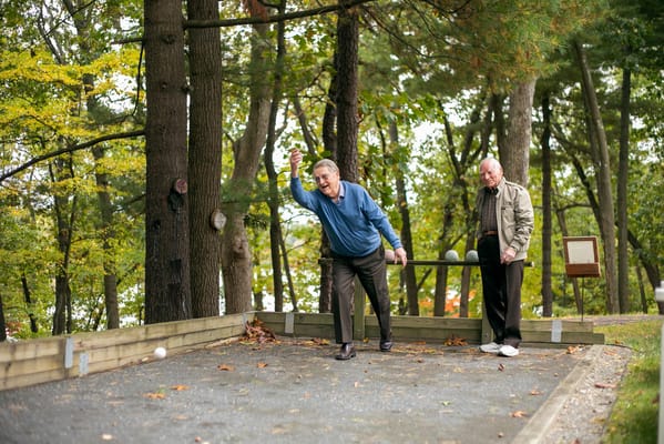 Seniors enjoying a game outdoors among trees