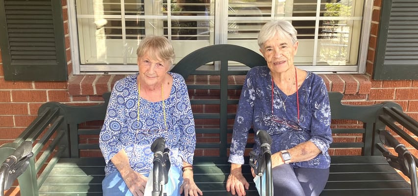 Two residents sitting on a bench outdoors