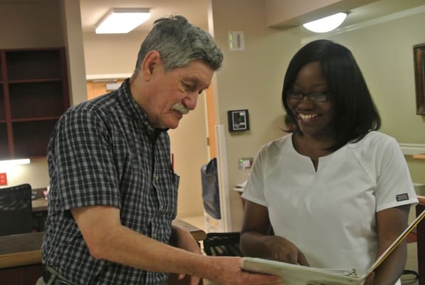 A staff member and resident sharing a binder in the interior