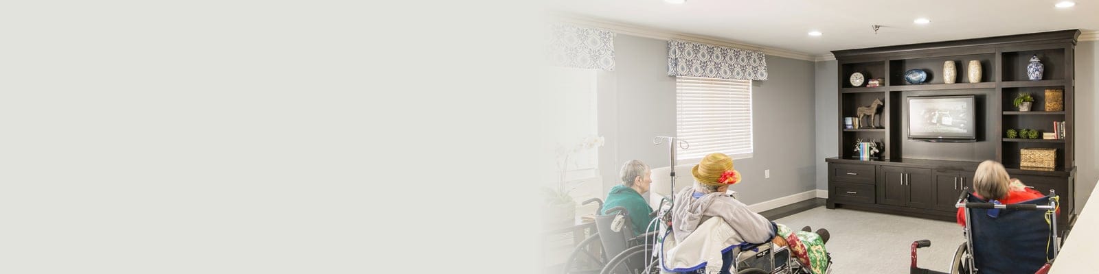 Residents enjoying a common area in wheelchairs.