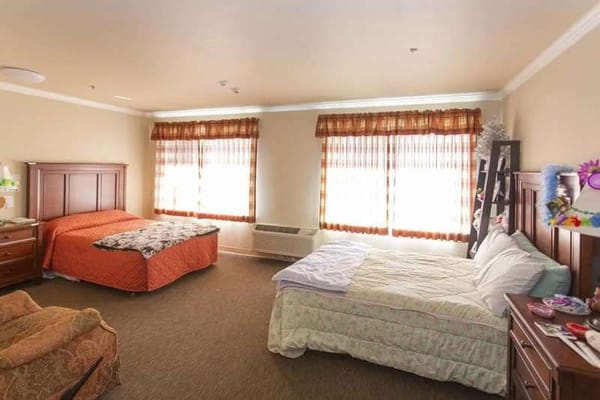 Interior view of a resident room with beds and furniture
