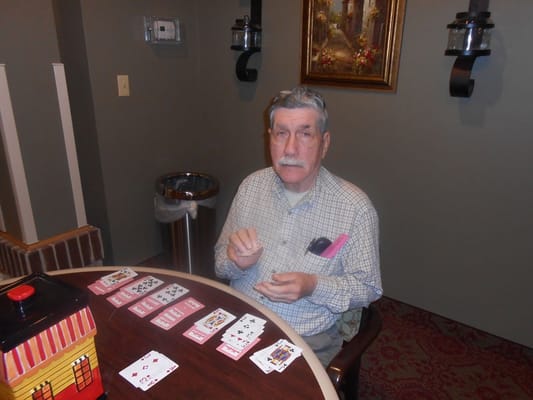 Senior resident playing cards at a table