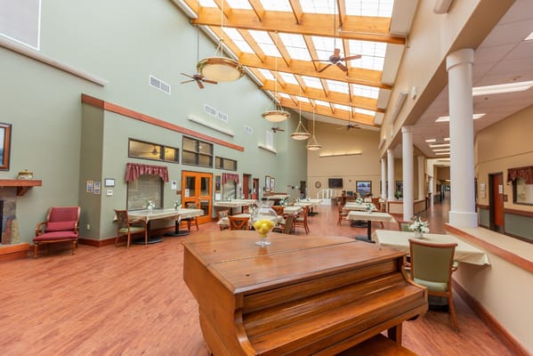 Bright common area with tables and piano