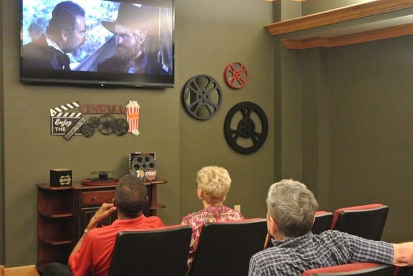 Residents watching a movie in a cozy common area