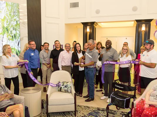 Residents and staff at a ribbon-cutting ceremony in the lobby