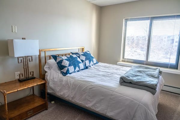 Well-lit private bedroom with a bed and lamp
