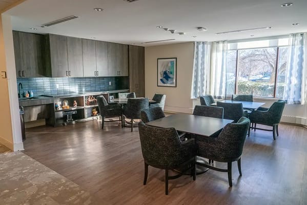 Common area with tables and chairs in a well-lit room