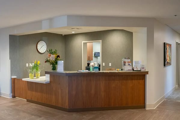 Bright reception area with flowers and a clock
