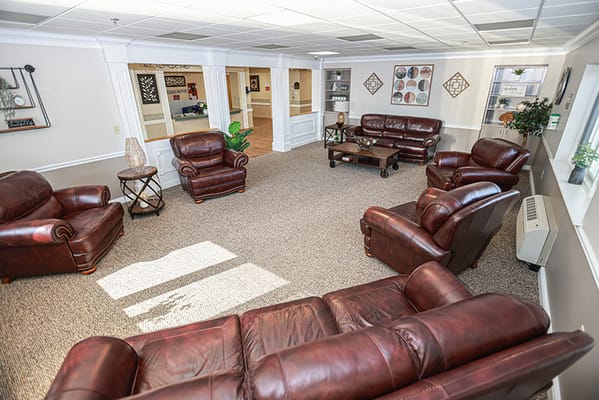 Lounge area with leather sofas and sunlight streaming in