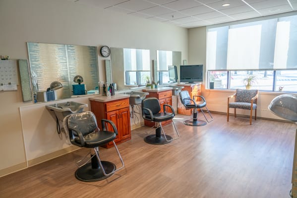 Well-lit beauty salon area with styling stations.