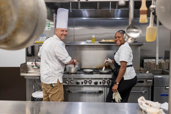 Two chefs preparing meals in a kitchen