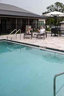 Residents relaxing by the poolside in a cozy setting