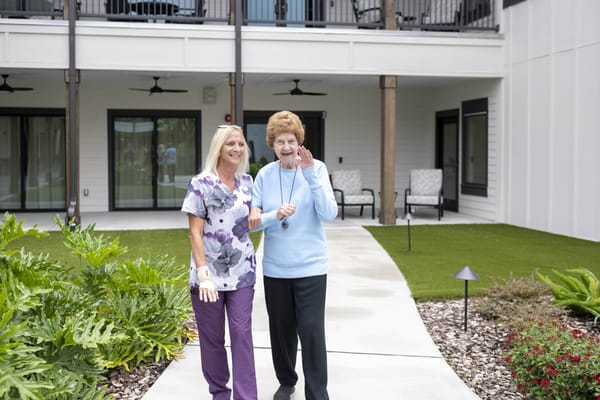 A staff member and resident interacting in the garden area