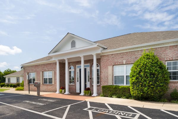 Entrance with pillars and landscaped front of Azalea Estates Assisted Living
