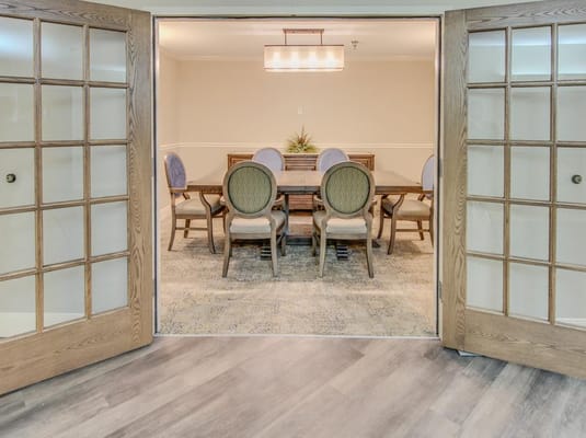 View into a dining area with a large table and chairs